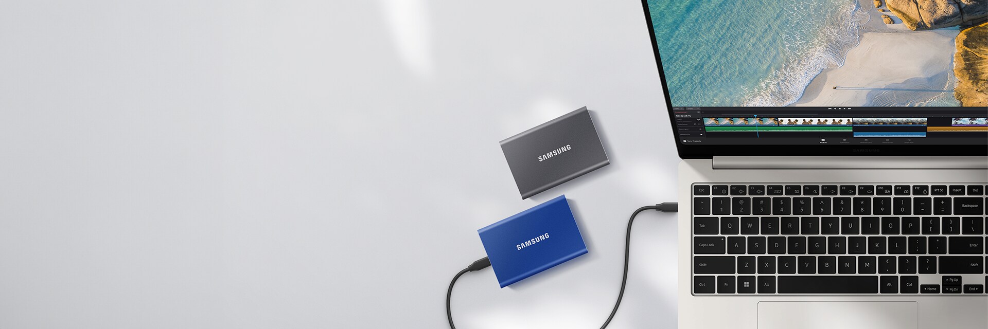 A laptop running a video editing program and two Samsung T7s are visible.